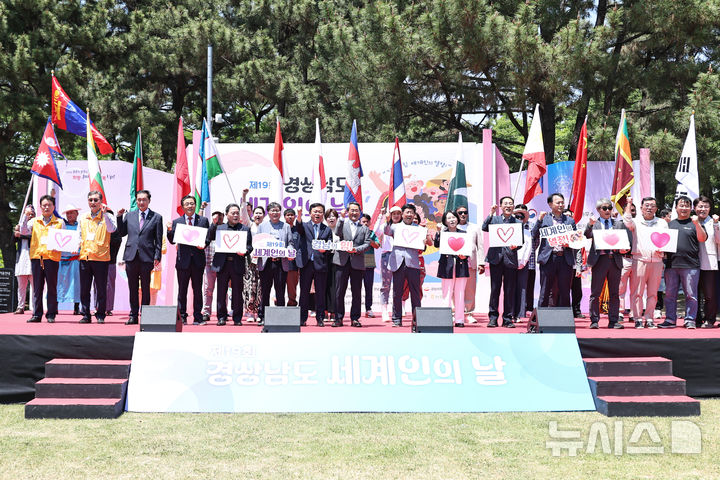 [창원=뉴시스]17일 경남도청 잔디광장에서 열린 제19회 세계인의 날 기념행사에 참석한 박일웅 도지사 권한대행과 15개국 기수단 등이 기념촬영하고 있다.(사진=경남도 제공) 2026.05.17. photo@newsis.com