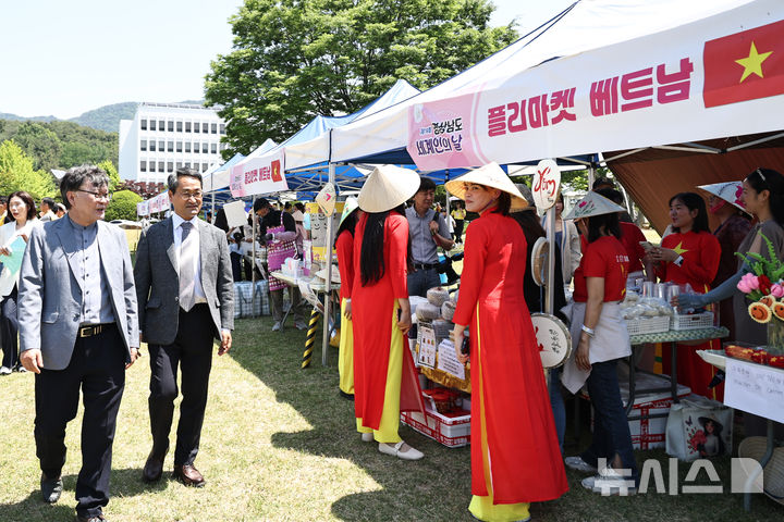 [창원=뉴시스]17일 경남도청 잔디광장에서 열린 제19회 세계인의 날 기념행사에 참석한 박일웅(왼쪽서 두 번째) 도지사 권한대행이 기념식 후 메트남 등 각국 홍보 부스를 둘러보고 있다.(사진=경남도 제공) 2026.05.17. photo@newsis.com