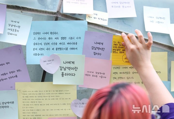 [서울=뉴시스] 김진아 기자 = '강남역 여성살해사건 10주기 추모행동'이 진행된 17일 서울 강남역 10번 출구에서 한 시민이 추모 문구를 적은 포스트잇을 붙이고 있다. 2026.05.17. bluesoda@newsis.com