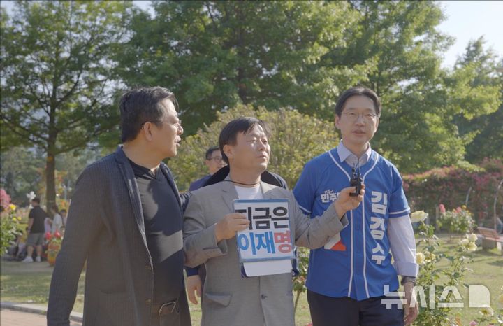 [창원=뉴시스]더불어민주당 김경수(오른쪽) 경남도지사 후보가 지난 17일 오후 4시 창원특례시 성산구 가음동 장미공원에서 유튜브 채널 안진걸TV의 '안진걸이 간다' 라이브 방송에 출연해 인터뷰를 하고 있다. 왼쪽은 드라마 ‘이상한 변호사 우영우’ 등에 출연한 이기영 배우.(사진=김경수후보 선거사무소 제공) 2026.05.18. photo@newsis.com