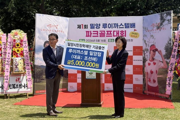 [밀양=뉴시스] 루이까스텔 밀양점 조선애 대표를 대신해 배우자 손호대씨가 삼문동 파크골프장에서 서연주 이사에게 장학기금 500만원을 전달하고 있다. (사진=밀양시 제공) 2026.05.18. photo@newsis.com *재판매 및 DB 금지