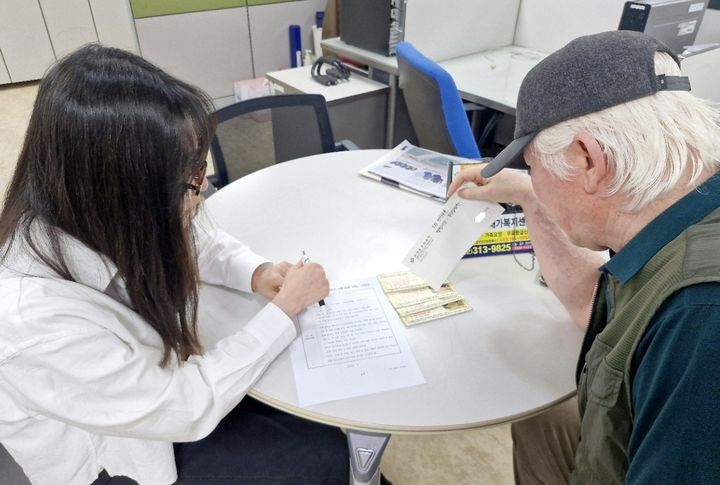 [서울=뉴시스]서대문구 천연동의 한 중장년 주민이 관내 전통시장 반찬 가게에서 사용할 수 있는 쿠폰을 받고 있다. (사진=서대문구 제공) 2026.05.18. photo@newsis.com *재판매 및 DB 금지
