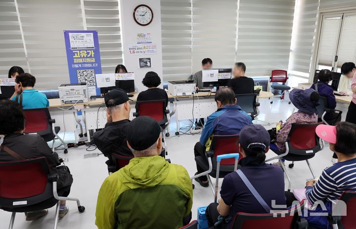  [부산=뉴시스] 하경민 기자 = 정부 고유가 피해지원금 2차 신청·지급 첫날인 18일 부산 부산진구 개금3동행정복지센터에서 주민들이 선불카드형 지원금을 받고 있다. 2026.05.18. yulnetphoto@newsis.com