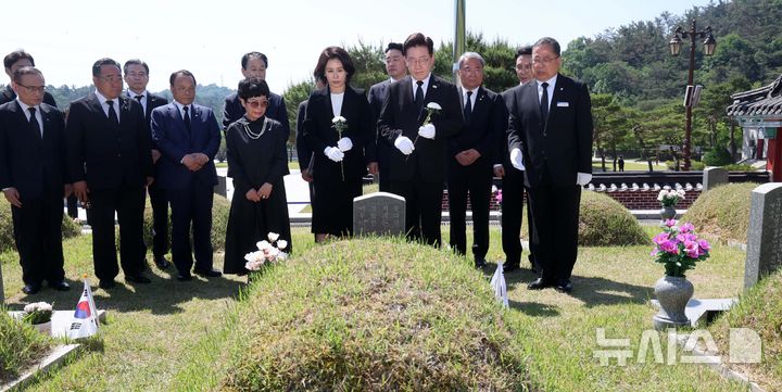 [광주=뉴시스] 고범준 기자 = 이재명 대통령과 김혜경 여사가 18일 광주 북구 국립5·18민주묘지에서 고 박인배 열사 묘소를 찾아 헌화하고 있다. 2026.05.18. bjko@newsis.com
