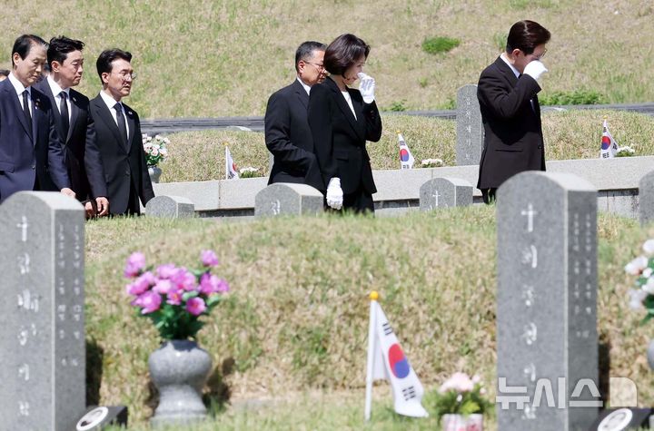 [광주=뉴시스] 고범준 기자 = 이재명 대통령과 김혜경 여사가 18일 광주 북구 국립5·18민주묘지에서 묘역을 둘러보며 눈물을 닦고 있다. 2026.05.18. bjko@newsis.com