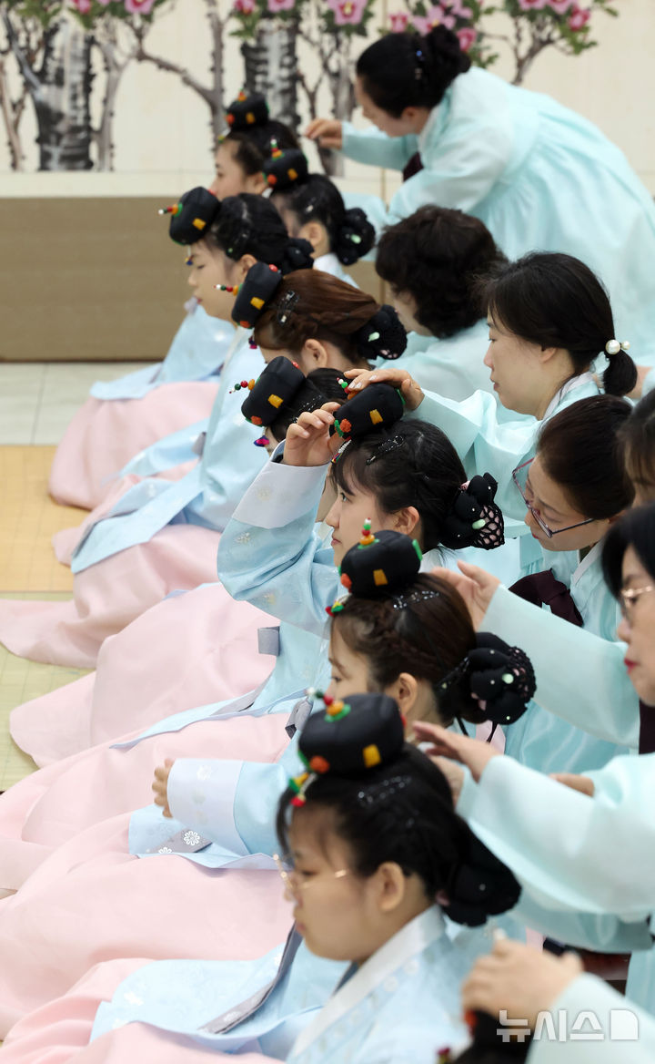  [부산=뉴시스] 하경민 기자 = 제54회 성년의 날인 18일 부산 사상구 부산시여성문화회관 대강당에서 열린 '전통 성년례'에 참가한 남녀 성년자들이 갓을 쓰고 비녀를 꽂는 의식인 관례와 계례를 하고 있다. 2026.05.18. yulnetphoto@newsis.com