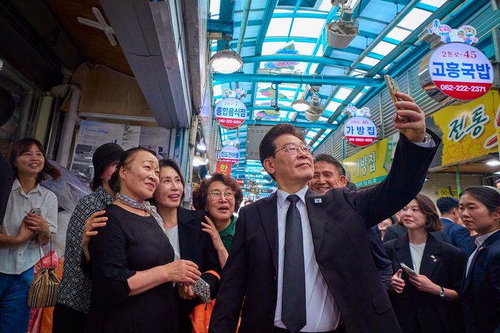 [서울=뉴시스] 최동준 기자 = 이재명 대통령과 김혜경 여사가 18일 광주 동구 남광주시장을 방문해 시민들과 셀카를 찍고 있다. (사진=청와대 제공) 2026.05.18. photo@newsis.com *재판매 및 DB 금지