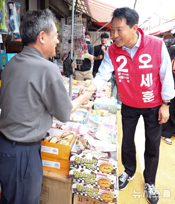[서울=뉴시스] 최진석 기자 = 오세훈 국민의힘 서울시장 후보가 19일 서울 종로구 창신동 문구완구거리에서 오세훈과 함께 걸어요를 하며 상인과 인사하고 있다. 2026.05.19. myjs@newsis.com