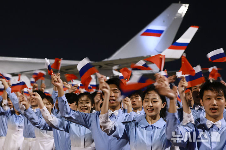 [베이징=AP/뉴시스] 19일(현지 시간) 중국 베이징 서우두 공항에서 중국 청년들이 러시아 국기를 흔들며 블라디미르 푸틴 러시아 대통령을 환영하고 있다. 푸틴 대통령은 시진핑 중국 국가주석의 초청으로 19일부터 20일까지 중국을 국빈 방문한다. 2026.05.20.
