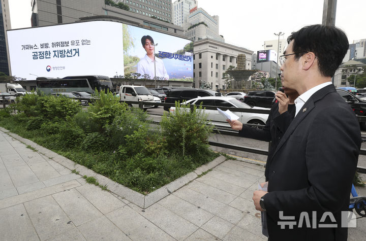 [서울=뉴시스] 김민재 행정안전부 차관이 지난 19일 서울 중구 자유표시구역 내 신세계 백화점 본점 대형 전광판을 찾아 투표 참여 홍보와 가짜뉴스 근절 영상 송출 상황을 점검하고 있다. (사진=행정안전부 제공) 2026.5.20 photo@newsis.com