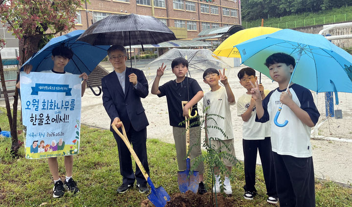 [광주=뉴시스] 광주 한울초등학교 학생들과 서성길 교장이 20일 교내 유휴 부지에서 옛 전남도청 앞 회화나무 후계목을 식재했다. 2026.05.20. (사진=광주시교육청 제공) photo@newsis.com *재판매 및 DB 금지