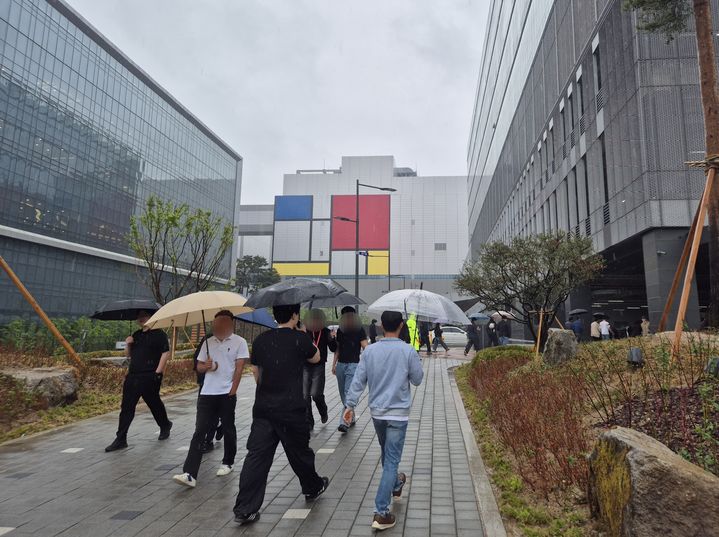 [평택=뉴시스] 이병희 기자 = 삼성전자 노사가 총파업 예정일을 하루 앞둔 20일 오후 3시께 경기 평택시 고덕동 삼성전자 평택캠퍼스에서 우산을 쓰고 움직이는 직원들. 2026.05.20. iambh@newsis.com *재판매 및 DB 금지