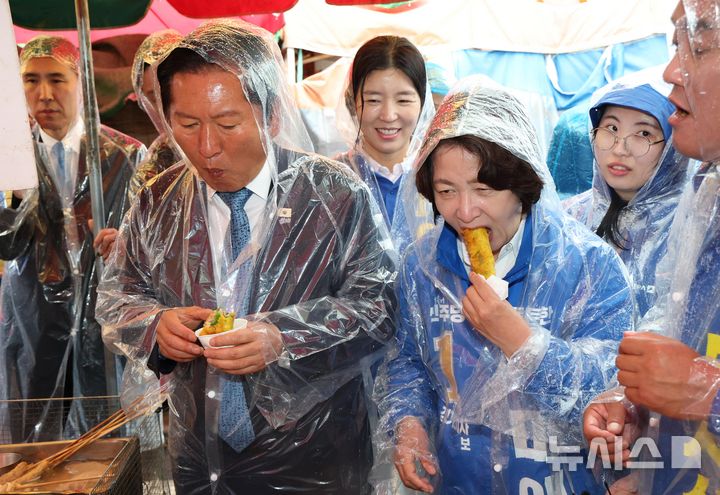 [여주=뉴시스] 김종택 기자 = 정청래 더불어민주당 대표와 추미애 경기도지사 후보가 20일 오전 경기 여주시 여주한글시장을 방문해 튀김을 먹고 있다. (공동취재) 2026.05.20. photo@newsis.com
