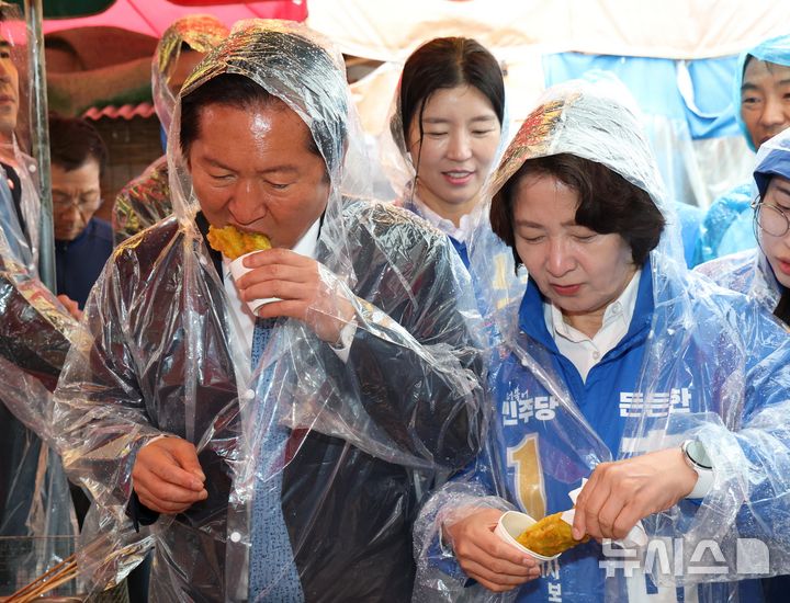 [여주=뉴시스] 김종택 기자 = 정청래 더불어민주당 대표와 추미애 경기도지사 후보가 20일 오전 경기 여주시 여주한글시장을 방문해 튀김을 먹고 있다. (공동취재) 2026.05.20. photo@newsis.com