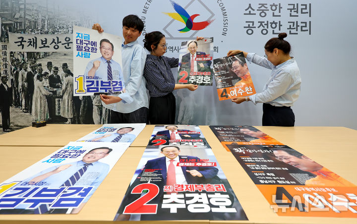 [대구=뉴시스] 이무열 기자 = 제9회 전국동시지방선거를 앞둔 20일 대구 서구 대구시선거관리위원회에서 관계자들이 접수된 대구시장 후보들의 선거벽보를 살펴보고 있다. 2026.05.20. lmy@newsis.com