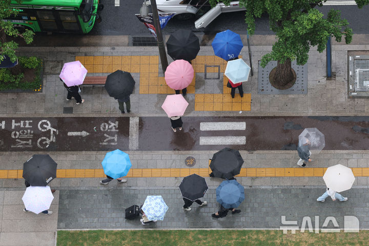 [서울=뉴시스] 권창회 기자 = 비가 내리는 20일 서울 중구 서울시청 인근에서 우산을 쓴 시민들이 우산을 쓰고 이동하고 있다. 2026.05.20. kch0523@newsis.com
