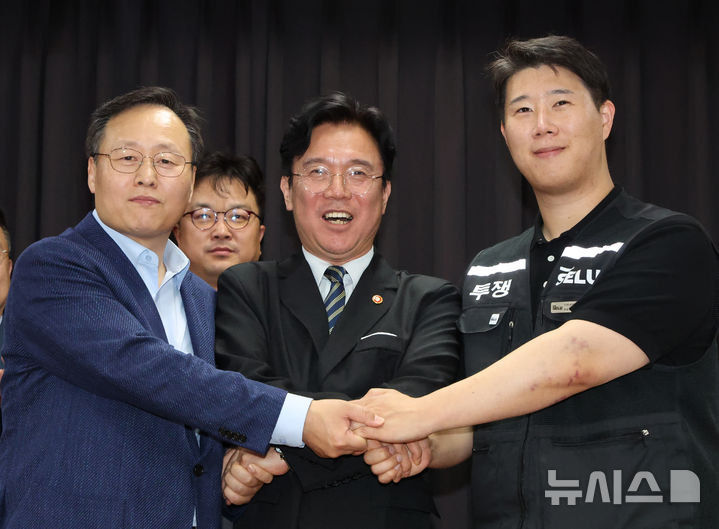 [수원=뉴시스] 김종택기자 = 20일 경기 수원시 장안구 경기고용노동청에서 열린 삼성전자 임금협상을 마친 후 여명구 삼성전자 DS(디바이스솔루션·반도체 사업 담당) 피플팀장(왼쪽부터)과 김영훈 고용노동부 장관, 최승호 삼성그룹 초기업노동조합 삼성전자지부 위원장이 잠정 합의한에 서명한 후 손을 맞잡고 파이팅을 외치고 있다. (공동취재) 2026.05.20. photo@newsis.com