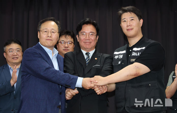 [수원=뉴시스] 김종택기자 = 20일 경기 수원시 장안구 경기고용노동청에서 열린 삼성전자 임금협상을 마친 후 여명구 삼성전자 DS(디바이스솔루션·반도체 사업 담당) 피플팀장(왼쪽부터)과 김영훈 고용노동부 장관, 최승호 삼성그룹 초기업노동조합 삼성전자지부 위원장이 잠정 합의한에 서명한 후 손을 맞잡고 있다. (공동취재) 2026.05.20. photo@newsis.com