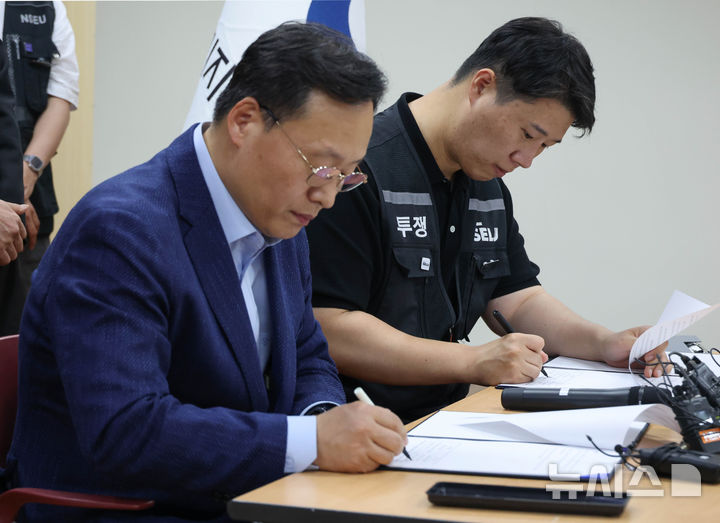 [수원=뉴시스] 김종택기자 = 여명구 삼성전자 DS(디바이스솔루션·반도체 사업 담당) 피플팀장(왼쪽)과 최승호 삼성그룹 초기업노동조합 삼성전자지부 위원장이 20일 오후 경기 수원시 장안구 경기지방고용노동청에서 열린 삼성전자 노사교섭 결과 브리핑에서 합의안에 서명을 하고 있다. (공동취재) 2026.05.20. photo@newsis.com
