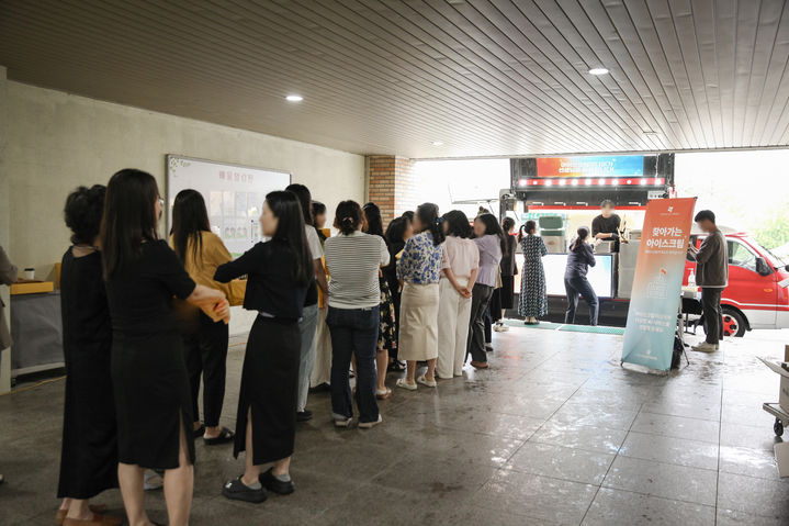대전배울초교 교직원들이 아이스크림미디어 '찾아가는 아이스크림, 간식차 이벤트'에 참여하고 있다. (사진=아이스크림미디어) *재판매 및 DB 금지