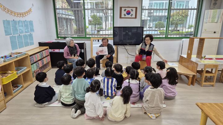 [광명=뉴시스] 광명시 노인일자리 지식 환원 사업인 '자연동화놀이'에 참여하는 어르신들이 아이들에게 동화를 읽어주고 있다. (사진=광명시 제공) 2026.05.21. photo@newsis.com *재판매 및 DB 금지