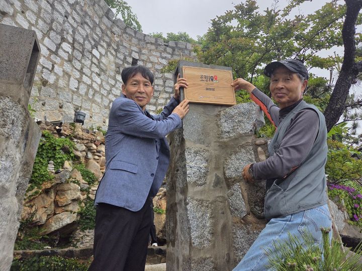  [거제=뉴시스] 경남 거제시 장목면 복항마을에 위치한 '거제 매미성'이 문화체육관광부와 지역문화진흥원이 추진하는 제2기 로컬100(2026~2027)에 선정돼 '로컬100' 을 달았다. 매미성주 백순삼씨(오른쪽)의 '로컬100' 현판식 모습. (사진=거제시 제공) 2026.05.21. photo@newsis.com *재판매 및 DB 금지
