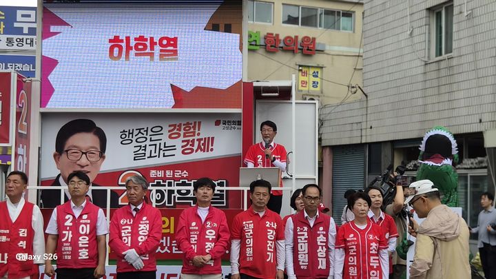 [고성(경남)=뉴시스] 신정철 기자= 국민의힘 경남 고성군 선거대책위원회는 21일 오전 10시, 송학교 및 공룡시장 일원에서 다가오는 지방선거의 압도적 승리를 다짐하는 ‘필승 출정식’을 개최하고 본격적인 선거 운동의 막을 올렸다. 사진은 하학열 군수 후보가 '행정은 경험이고 경제는 결과'라는 슬로건을 앞세우며 지지를 호소하고 있다.(사진=하학열후보선대위 제공).2026.05.21. photo@newsis.com *재판매 및 DB 금지