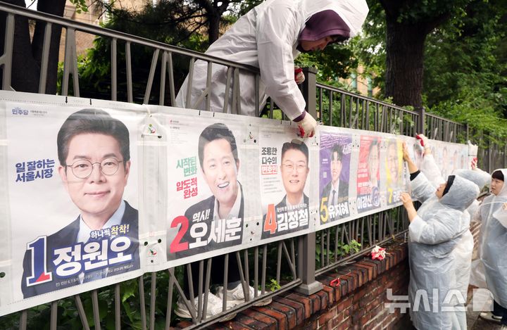 [서울=뉴시스] 전신 기자 = 지난 5월 21일 서울 종로구 예술가의 집 담장에서 서울시선관위 직원들이 제9회 전국동시지방선거 선거벽보를 붙이고 있다. 2026.05.21. photo1006@newsis.com