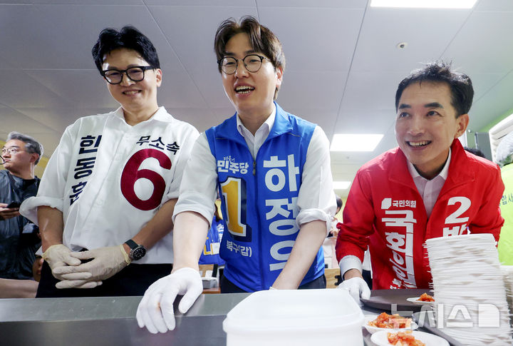 [부산=뉴시스] 김진아 기자 = 제9회 전국동시지방선거 및 국회의원 재·보궐선거의 공식 선거운동이 시작된 21일 부산 북구갑 국회의원 보궐선거 국민의힘 박민식(오른쪽부터), 더불어민주당 하정우, 무소속 한동훈 후보가 부산 북구 남산정복지관에서 열린 콩국수 나눔행사에서 콩국수를 기다리고 있다. 2026.05.21. bluesoda@newsis.com