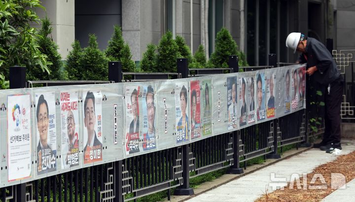  [부산=뉴시스] 하경민 기자 = 21일 부산 연제구의 한 거리에서 선거벽보 제작업체 관계자들이 건물 담장에 선거벽보를 부착하고 있다. 2026.05.21. yulnetphoto@newsis.com