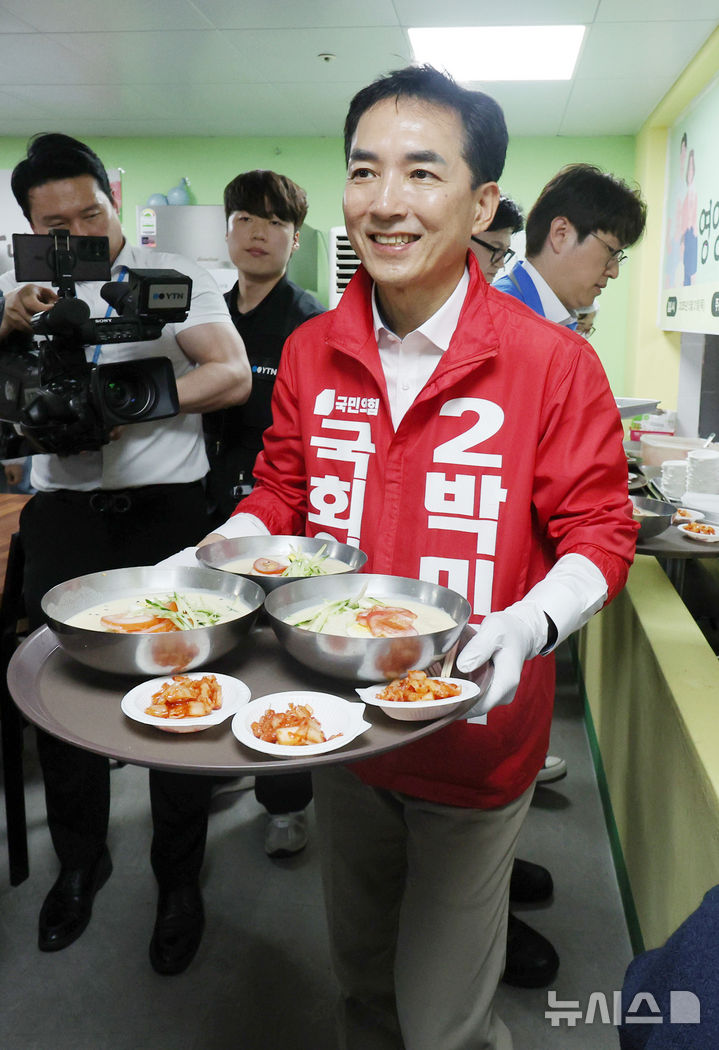 [부산=뉴시스] 김진아 기자 = 제9회 전국동시지방선거 및 국회의원 재·보궐선거의 공식 선거운동이 시작된 21일 박민식 국민의힘 부산 북구갑 국회의원 보궐선거 후보가 부산 북구 남산정복지관에서 열린 콩국수 나눔행사에서 콩국수를 나르고 있다. 2026.05.21. bluesoda@newsis.com