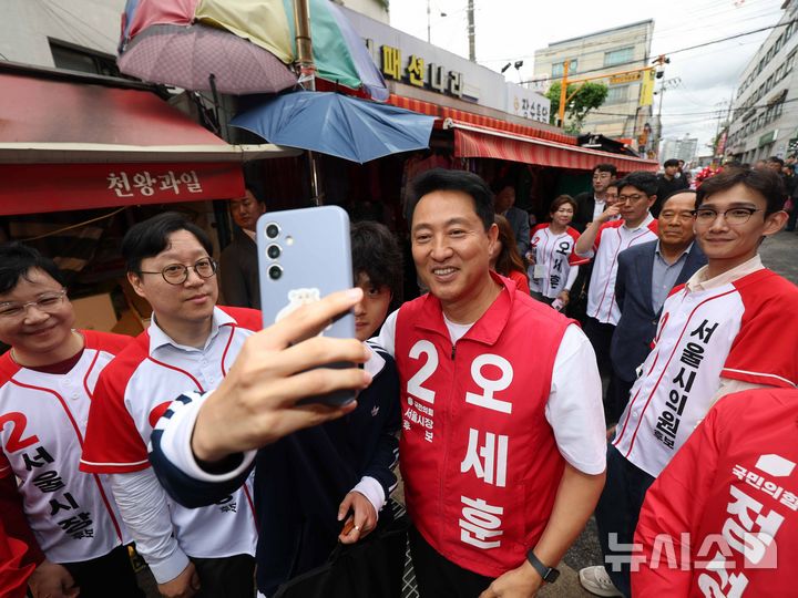 [서울=뉴시스] 김명년 기자 = 오세훈 국민의힘 서울시장 후보가 21일 오후 서울 구로구 남구로시장에서 시민과 셀카를 찍고 있다. 2026.05.21. kmn@newsis.com