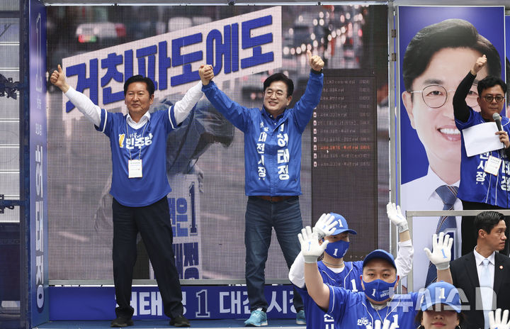 [대전=뉴시스] 김금보 기자 = 정청래(왼쪽) 더불어민주당 대표와 허태정 대전시장 후보자가 21일 오후 대전 중구 으느정이 문화의거리에서 선거 유세에서 두 손을 머리 위로 들고 있다. 2026.05.21. kgb@newsis.com