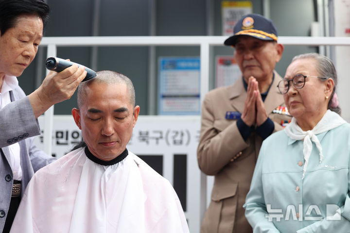 [부산=뉴시스] 김진아 기자 = 제9회 전국동시지방선거 및 국회의원 재·보궐선거의 공식 선거운동이 시작된 21일 박민식 국민의힘 부산 북구갑 국회의원 보궐선거 후보가 부산 북구 구포시장 앞에서 열린 출정식에서 삭발을 하고 있다. 2026.05.21. bluesoda@newsis.com