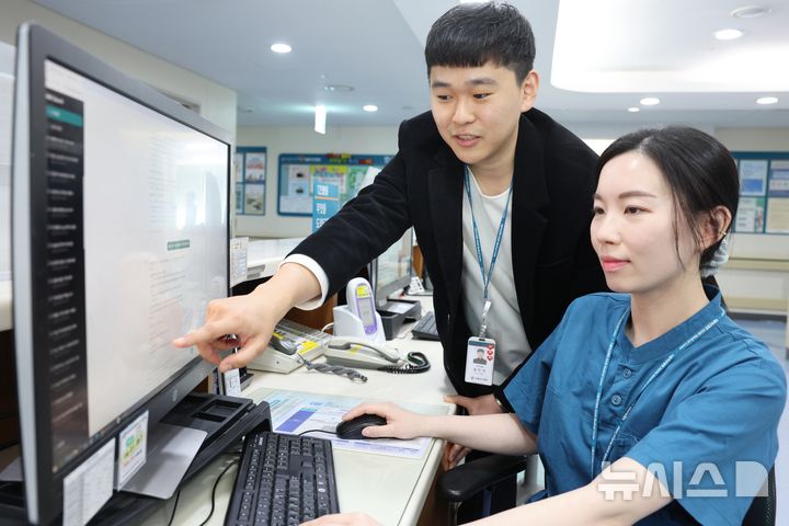 [서울=뉴시스] 임언석 서울아산병원 IT전략팀 주임(왼쪽)이 여건영 간호교육행정팀 대리에게 프라이빗 AI 지식 검색 시스템 활용법에 대해 설명하고 있다. (사진= 서울아산병원 제공)