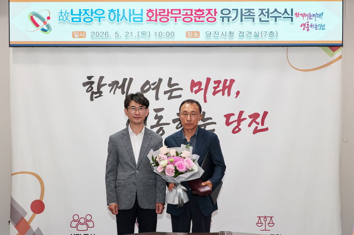 [당진=뉴시스] 지난 21일 당진시청 접견실에서 국방부장관을 대신해 황침현(왼쪽) 당진시장 권한대행이 남 하사 조카 남기범씨에게 화랑무공훈장을 건넨 후 기념 사진을 찍고 있다. (사진=당진시 제공) 2026.05.22. photo@newsis.com *재판매 및 DB 금지