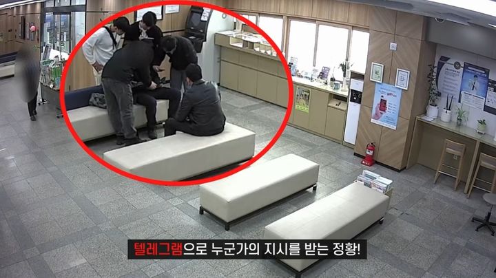[서울=뉴시스] 은행 측의 신고를 받고 출동한 경찰관들이 남성의 휴대전화를 확인하고 있다. (사진=경찰청 유튜브 채널 캡처) 2026.05.22. *재판매 및 DB 금지