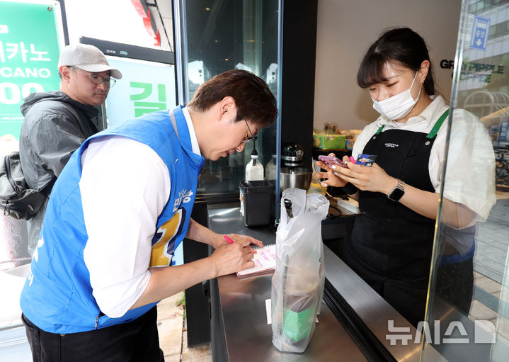 [부산=뉴시스] 김진아 기자 = 하정우 더불어민주당 부산 북구갑 국회의원 보궐선거 후보가 22일 부산 북구 만덕대로 일대에서 한 시민에게 사인을 해주고 있다. 2026.05.22. bluesoda@newsis.com