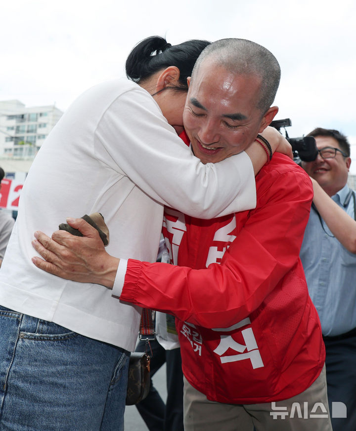 [부산=뉴시스] 김진아 기자 = 박민식 국민의힘 부산 북구갑 국회의원 보궐선거 후보가 22일 부산 북구 신만덕교차로 일대에서 거리유세를 하던 중 눈물을 흘리는 시민의 응원을 받으며 안아주고 있다. 2026.05.22. bluesoda@newsis.com