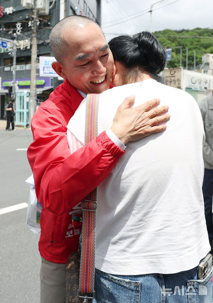 [부산=뉴시스] 김진아 기자 = 박민식 국민의힘 부산 북구갑 국회의원 보궐선거 후보가 22일 부산 북구 신만덕교차로 일대에서 거리유세를 하던 중 눈물을 흘리는 시민의 응원을 받으며 안아주고 있다. 2026.05.22. bluesoda@newsis.com