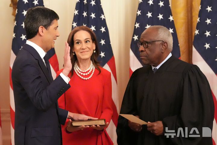 [워싱턴=AP/뉴시스]케빈 워시 연방준비제도(Fed 연준) 신임 의장이 22일(현지 시간) 백악관 이스트룸에서 아내와 함께 클래런스 토머스 연방대법관 주재로 취임 선서를 하고 있다. 2026.05.23.