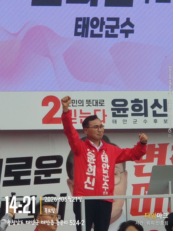 [태안=뉴시스] 윤희신 국민의힘 태안군수 후보가 지난 21일 태안읍 중앙로 광장 합동 출정식 자리에서 단상에 올라 주먹 쥔 손을 불끈 들고 있다. (사진=윤희신 후보 캠프 제공) 2026.05.22. photo@newsis.com *재판매 및 DB 금지