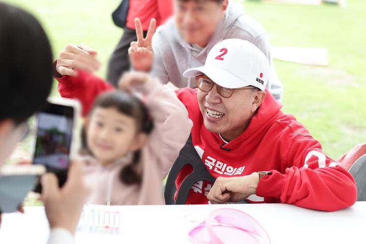[부산=뉴시스] 박형준 국민의힘 부산시장 후보가 23일 오후 북항친수공원에서 열린 세계시민축제를 찾아 아이와 사진을 찍고 있다. (사진=박형준 캠프 제공) 2026.05.23. photo@newsis.com *재판매 및 DB 금지