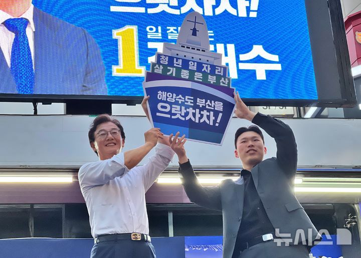 [부산=뉴시스] 원동화 기자 = 전재수 더불어민주당 부산시장 후보가 23일 부산 부산진구 서면 하트조형물 앞에서 대규모 유세를 펼쳤다. 한 청년으로부터 배 피켓을 받았다. 2026.05.23. dhwon@newsis.com