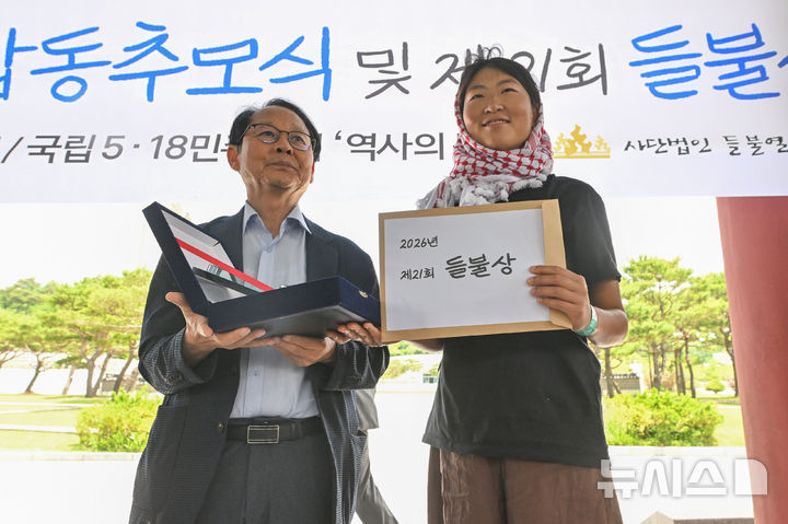 [광주=뉴시스] 이영주 기자 = 제21회 들불상 수상자로 선정된 평화활동가 김아현(활동명 해초·오른쪽)씨가 23일 오후 광주 북구 운정동 국립5·18민주묘지에서 열린 들불상 시상식에 참여해 상을 받고 있다. 2026.05.23. leeyj2578@newsis.com