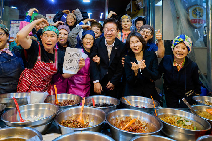 [서울=뉴시스] 최동준 기자 = 이재명 대통령과 김혜경 여사가 23일 경남 김해시 외동전통시장을 방문해 상인들과 기념촬영을 하고 있다. (사진=청와대 제공) 2026.05.23. photo@newsis.com *재판매 및 DB 금지