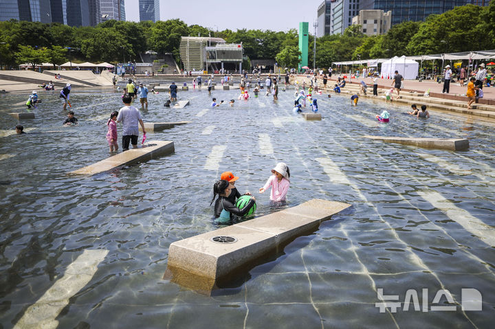 [서울=뉴시스] 정병혁 기자 = 초여름 날씨를 보인 24일 서울 영등포구 여의도한강공원 물빛광장을 찾은 시민들이 물놀이를 하며 즐거운 시간을 보내고 있다. 2026.05.24. jhope@newsis.com