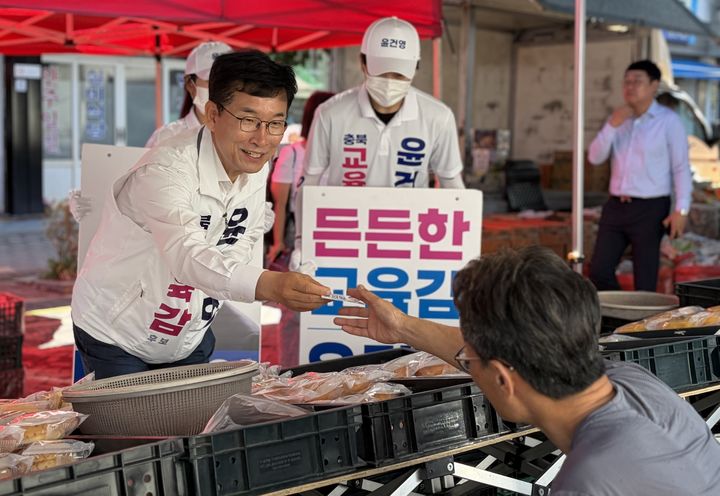 윤건영 충북교육감 후보가 25일 진천 전통시장에서 명함을 주며 상인과 인사하고 있다.(사진=윤 후보 캠프 제공)2026.05.25.photo@newsis.com *재판매 및 DB 금지