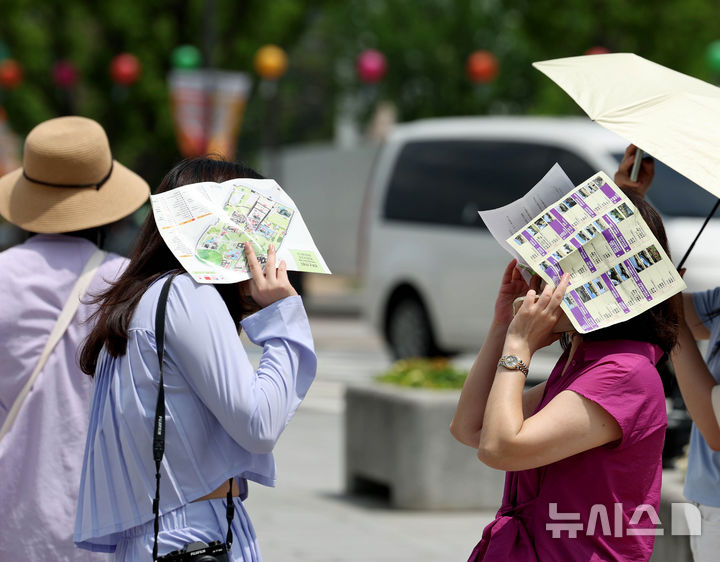 [서울=뉴시스] 조수정 기자 = 낮 최고기온 30도까지 오르며 초여름 더위를 보인 지난 25일 오후 서울 종로구 경복궁 앞에서 시민들이 종이로 햇빛을 가리고 있다. 2026.05.25. chocrystal@newsis.com