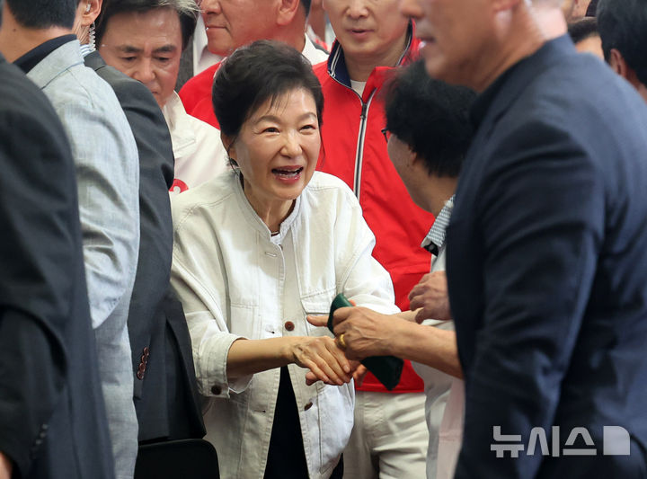 [공주=뉴시스] 배훈식 기자 = 박근혜 전 대통령이 지난 25일 오후 충남 공주시 산성시장을 찾아 한 시민과 악수하고 있다. 2026.05.22. dahora83@newsis.com